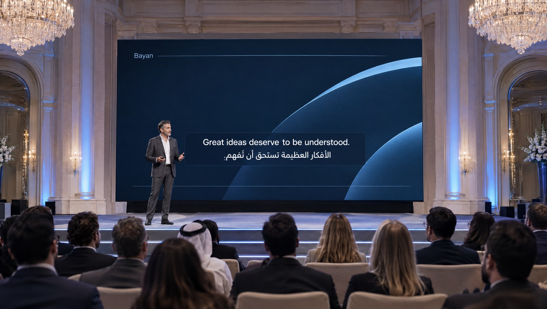 An adult presenter addresses professionals in a grand ballroom, with illustrative white English and Arabic captions on a presentation screen